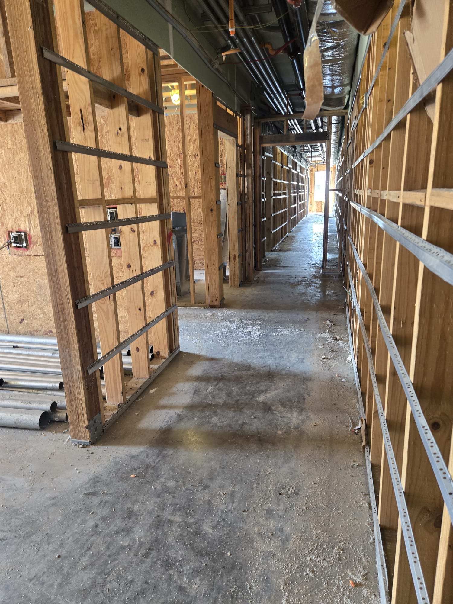Pasillo comercial en fase de enmarcado y drywall